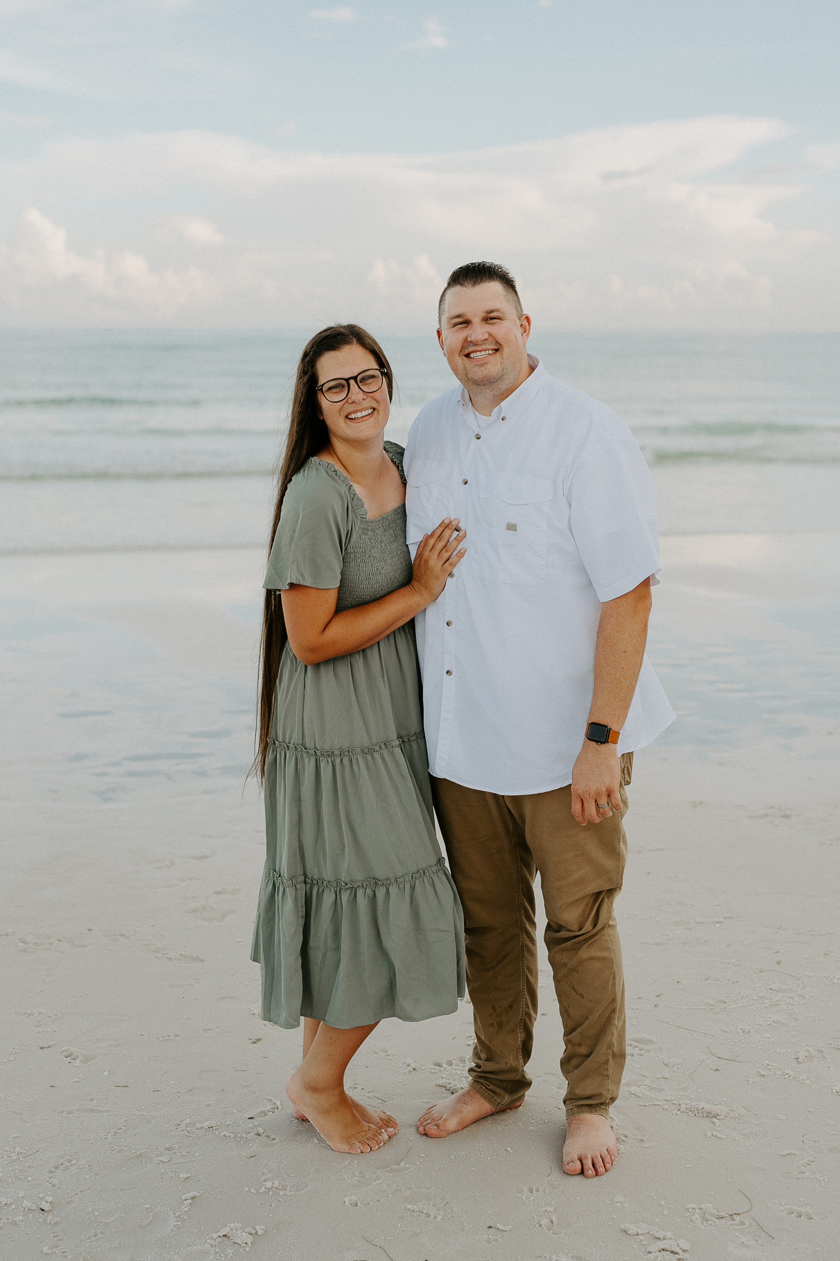 Rachel and her husband pose for a photo on the beach