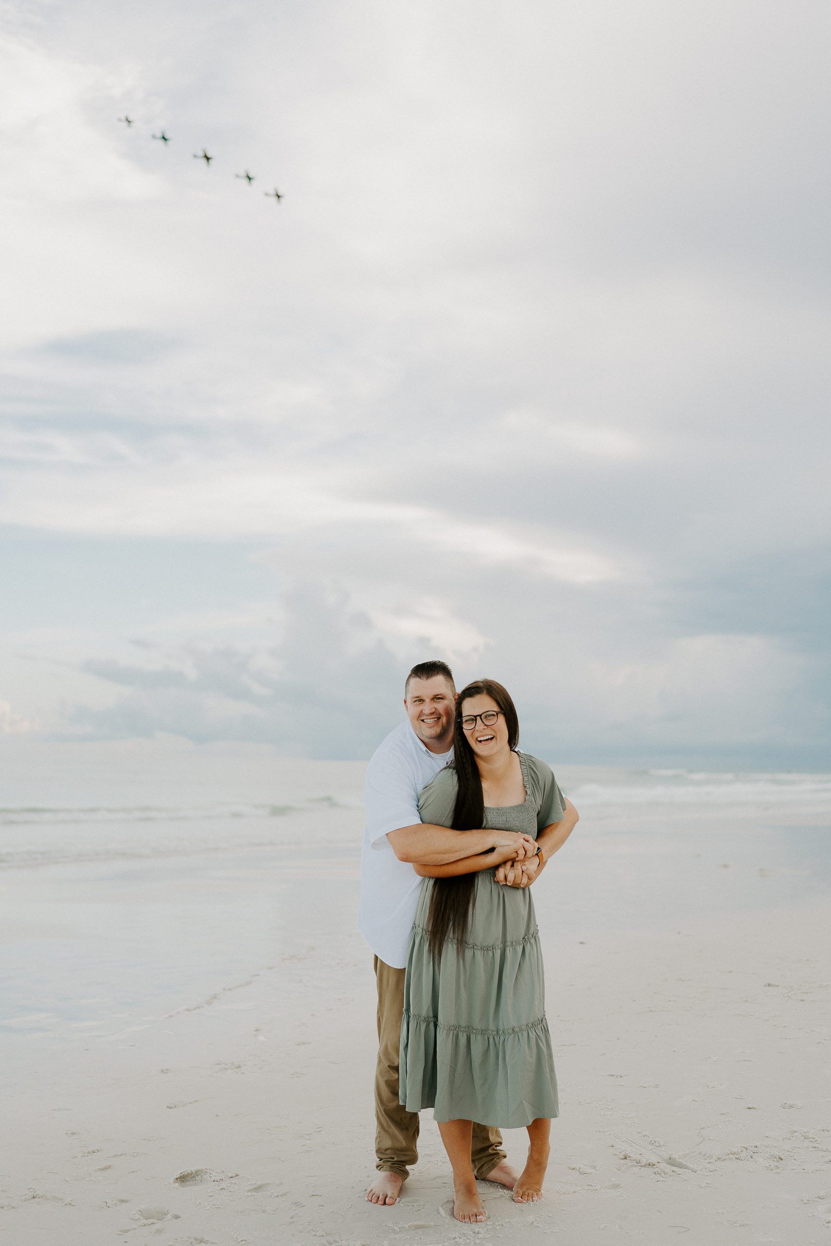 Rachel and her husband pose for a photo on the beach