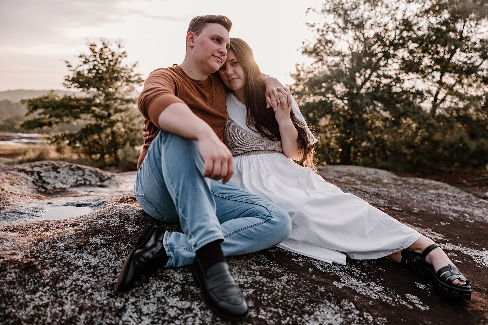 Adventure Couples Photo Session sitting on top of mountain during golden hour sunset. 
