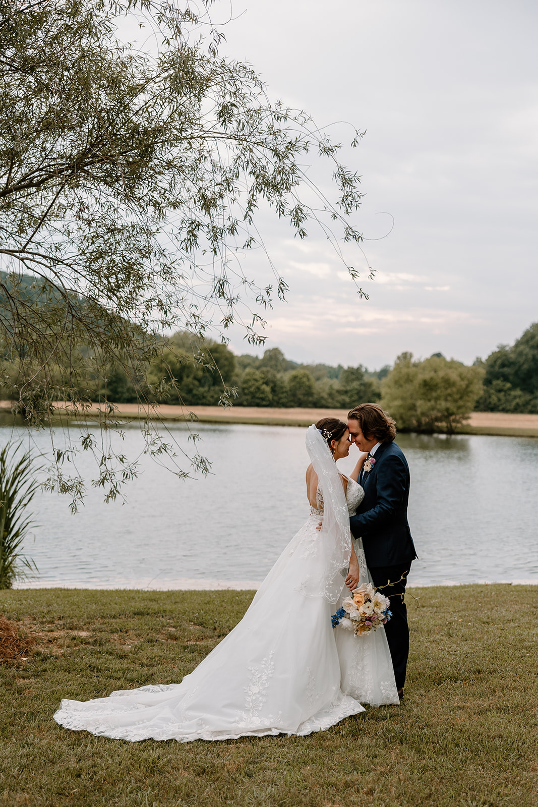 bride and groom kissing by the lake.