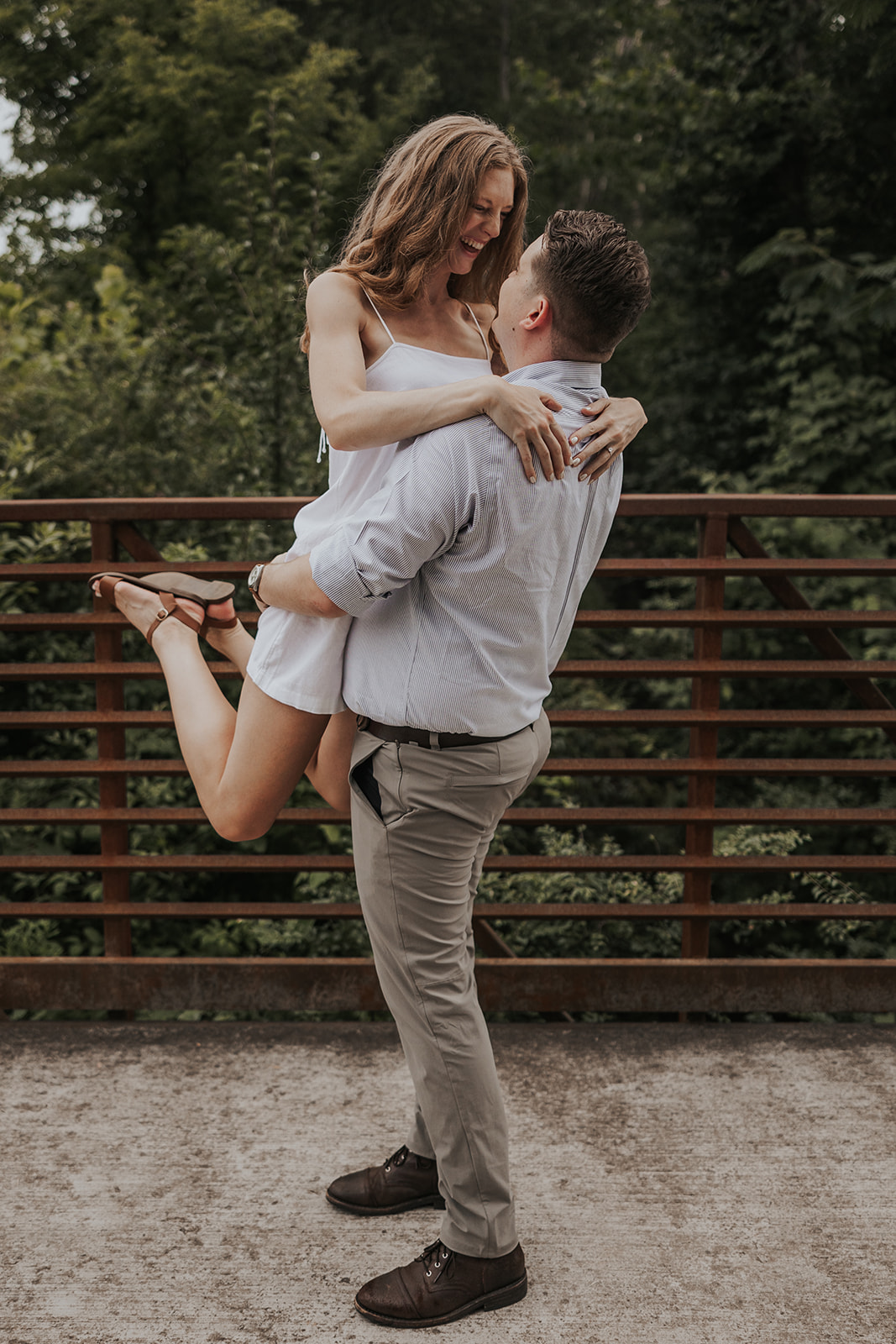 Stunning lady jumps into her fiance's arm on a pedestrian bridge during their engagement shoot!