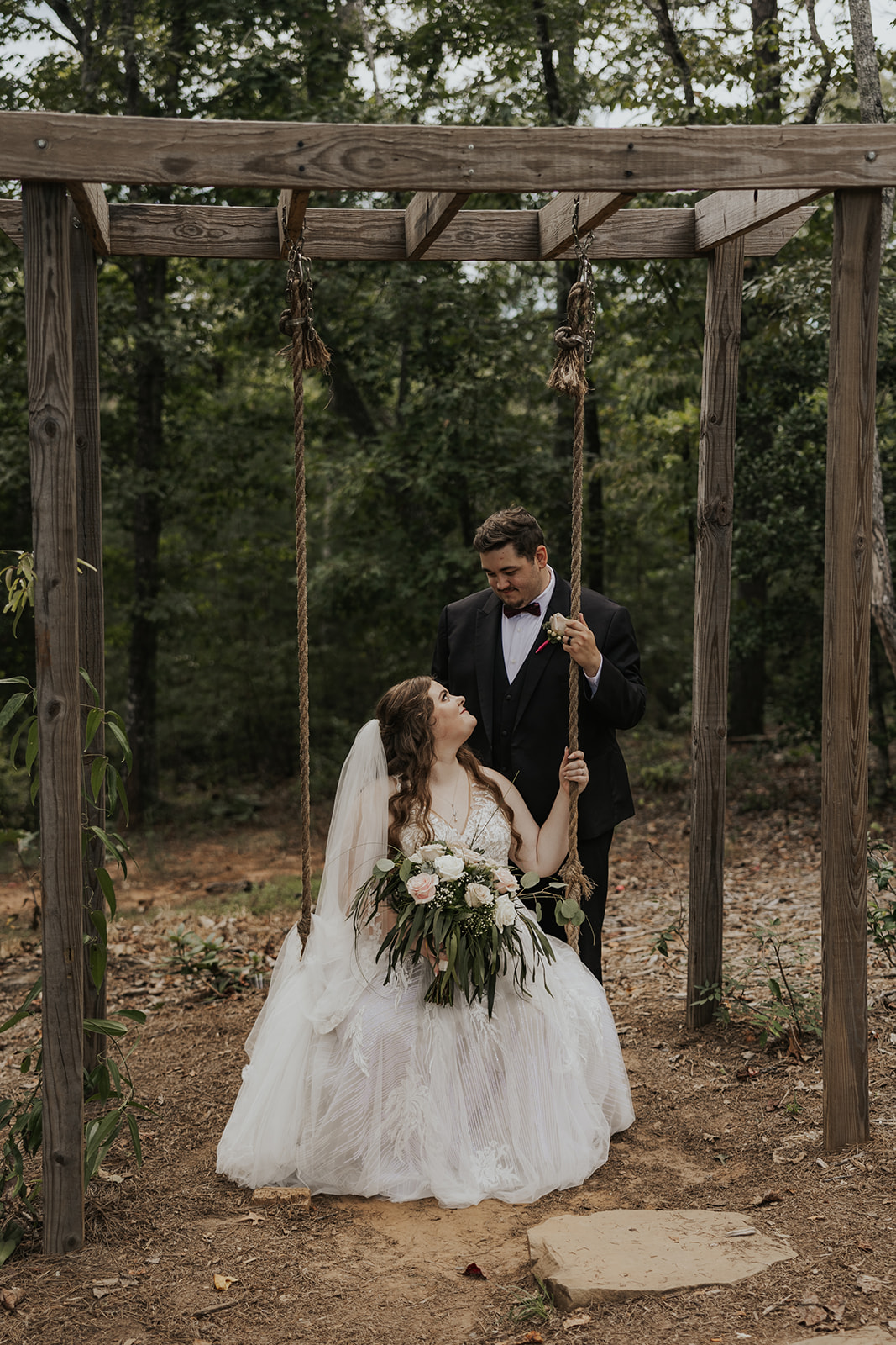Stunning bride and groom share a moment in the trees outside their Georgia wedding venue