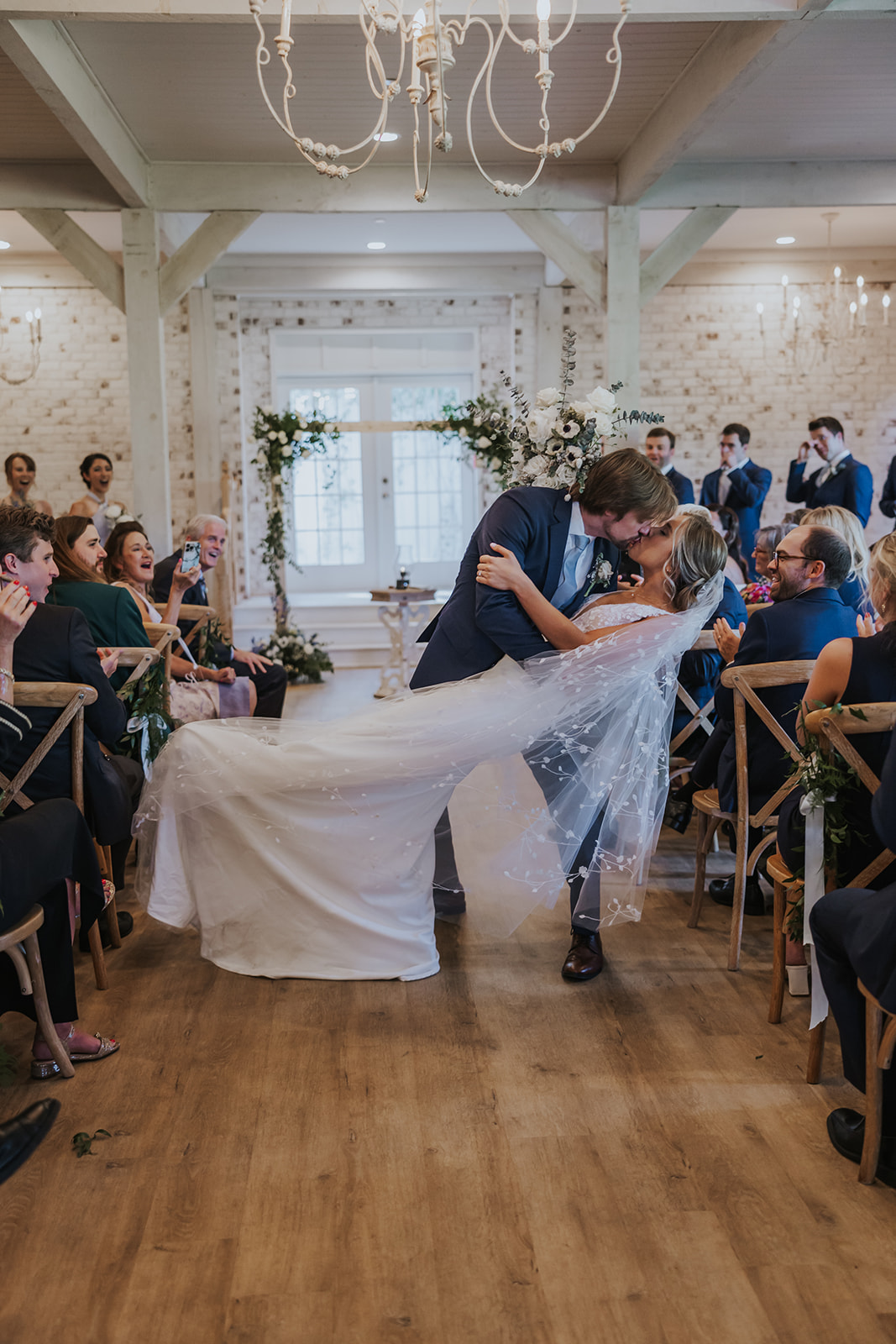 Stunning bride and groom share a kiss during their dreamy Georgia wedding at wildflower barn at little river farms