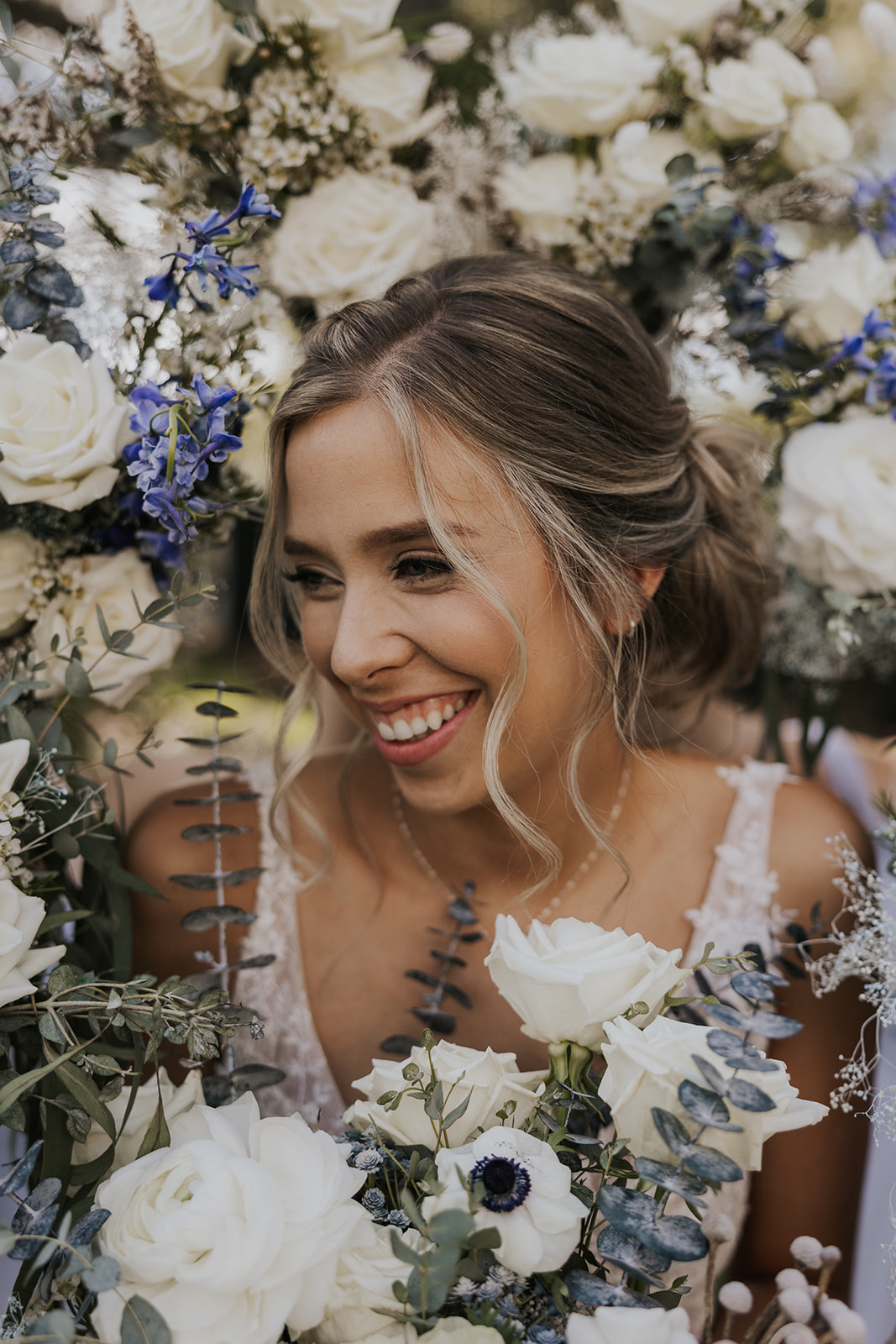 Stunning bride poses surrounded by flowers on her dreamy Georgia wedding day at wildflower barn at little river farms