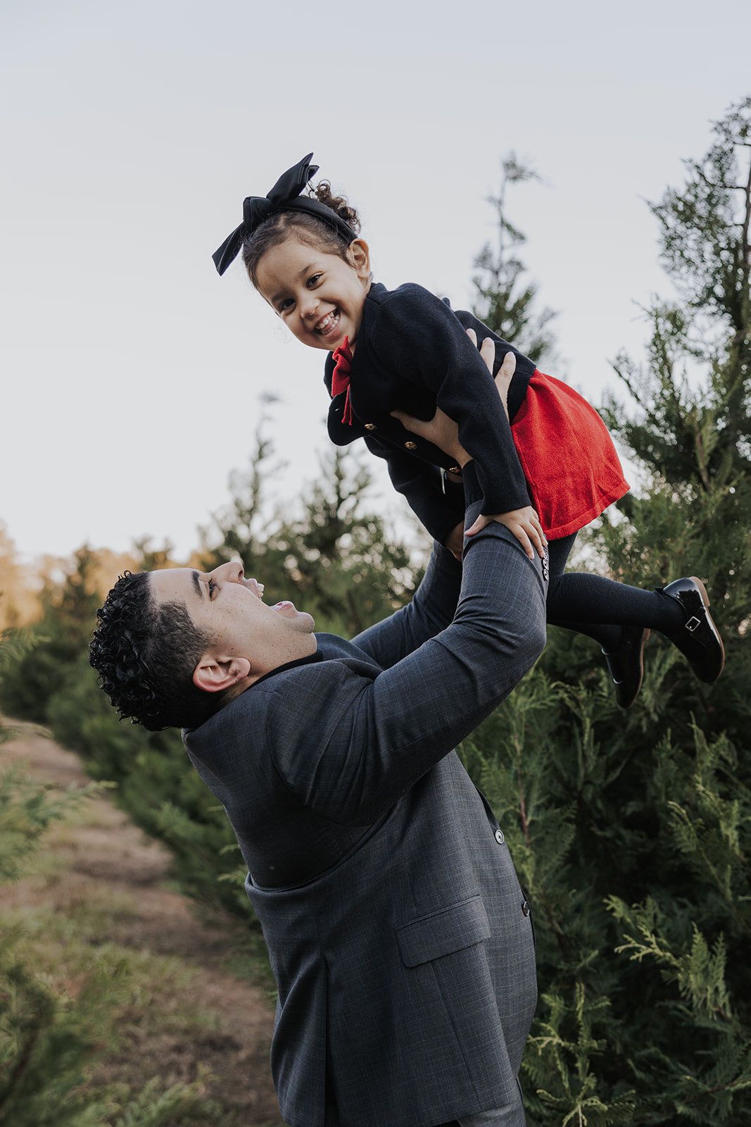 Dad and daughter pose together during their Christmas tree farm family photos