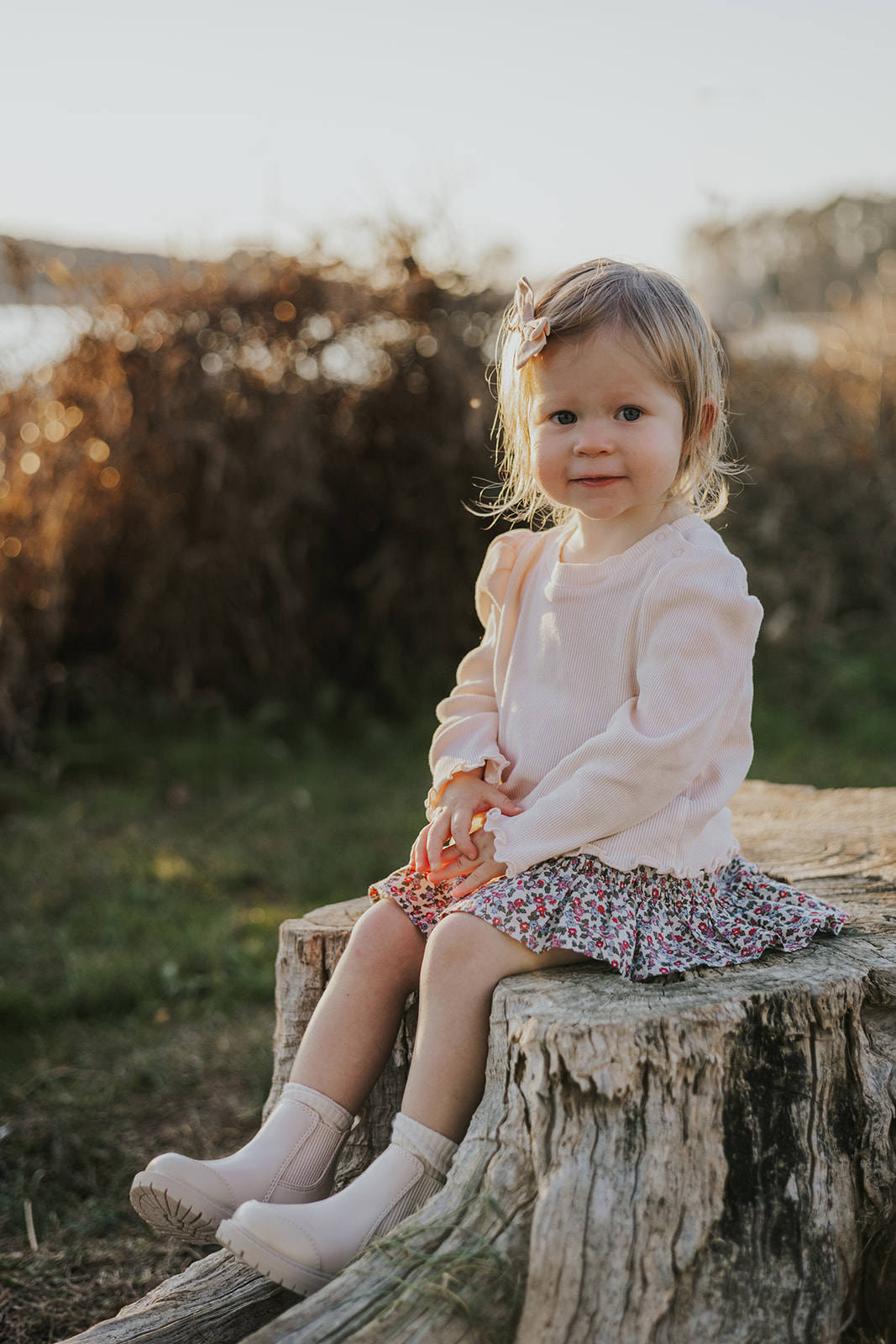 Young toddler sits on a stump beside a Georgia lake