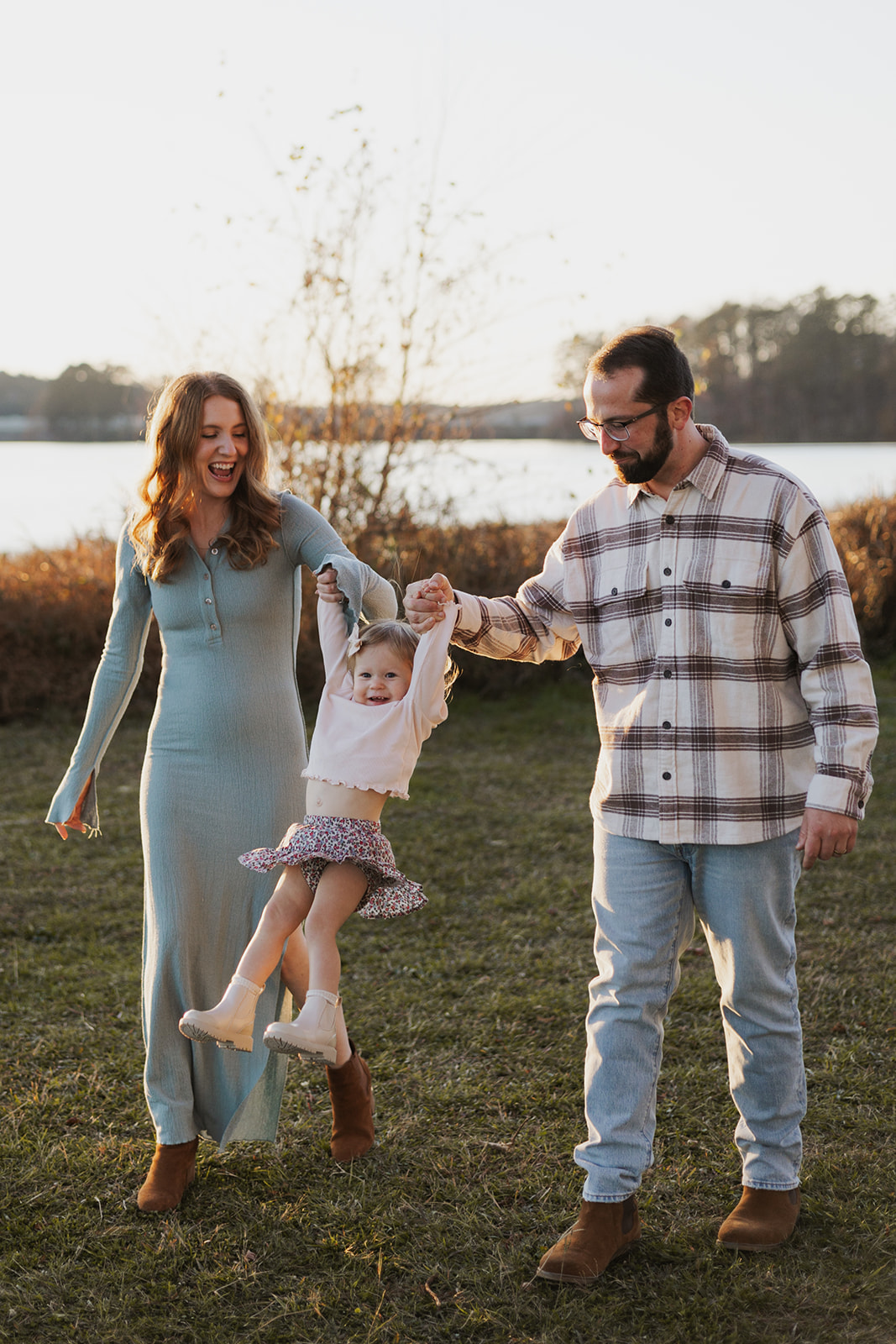 Stunning young family poses by a Georgia lake during their stress free family photos