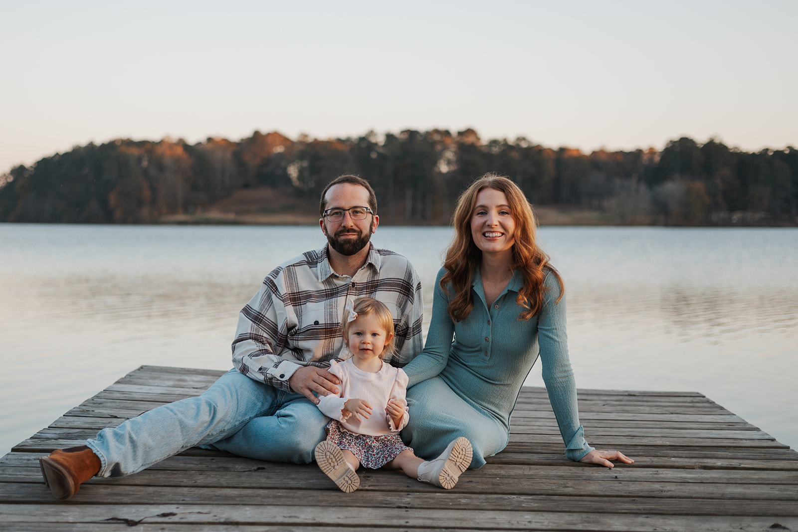 Stunning young family sits on a Georgia dock during their stress free family photos