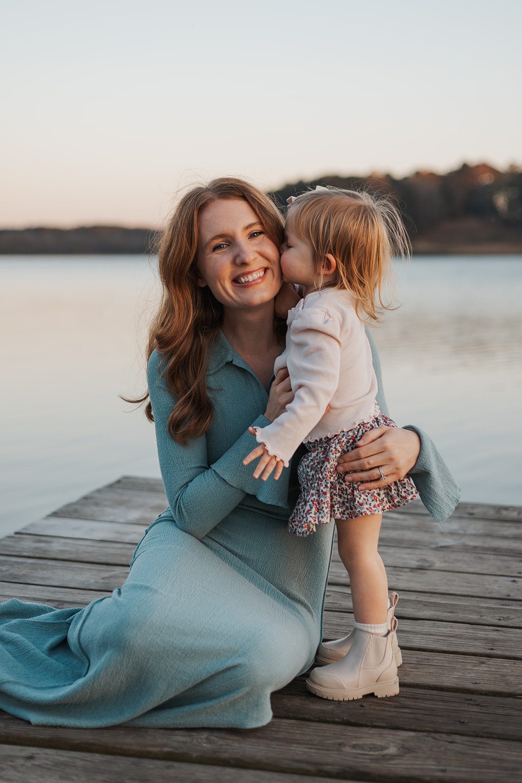 Young daughter gives her mom a kiss on the cheek during their Georgia family photoshoot