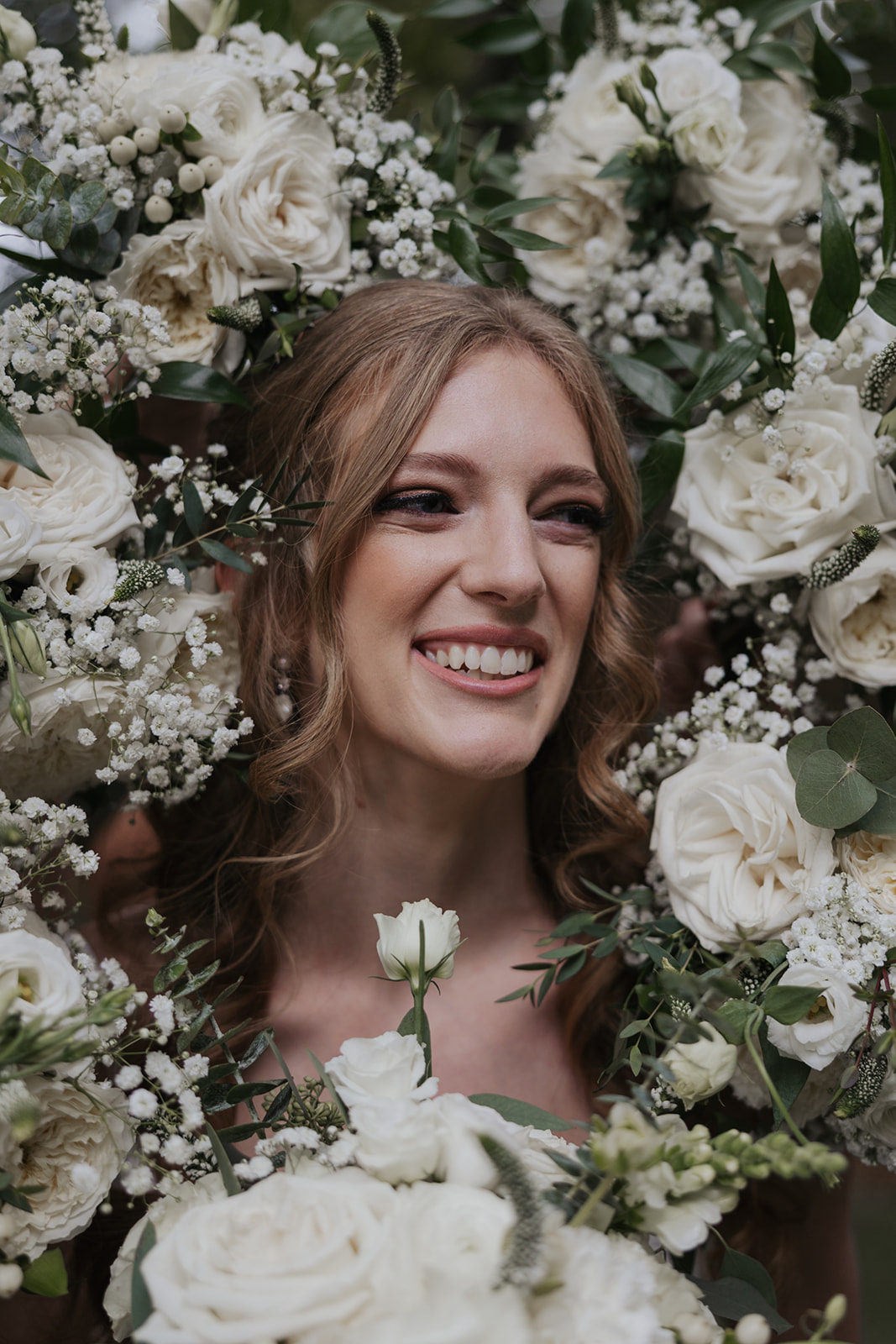 Beautiful bride poses surrounded by flowers