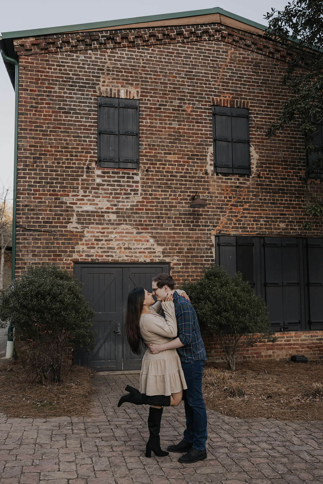Beautiful couple pose together against a brick wall backdrop