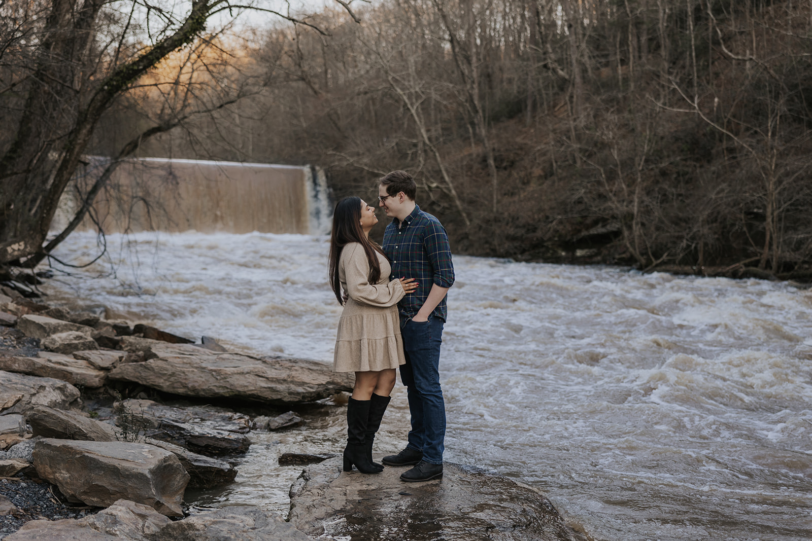 Beautiful couple pose beside the Roswell Mill Dam during their Roswell Mill engagement photos