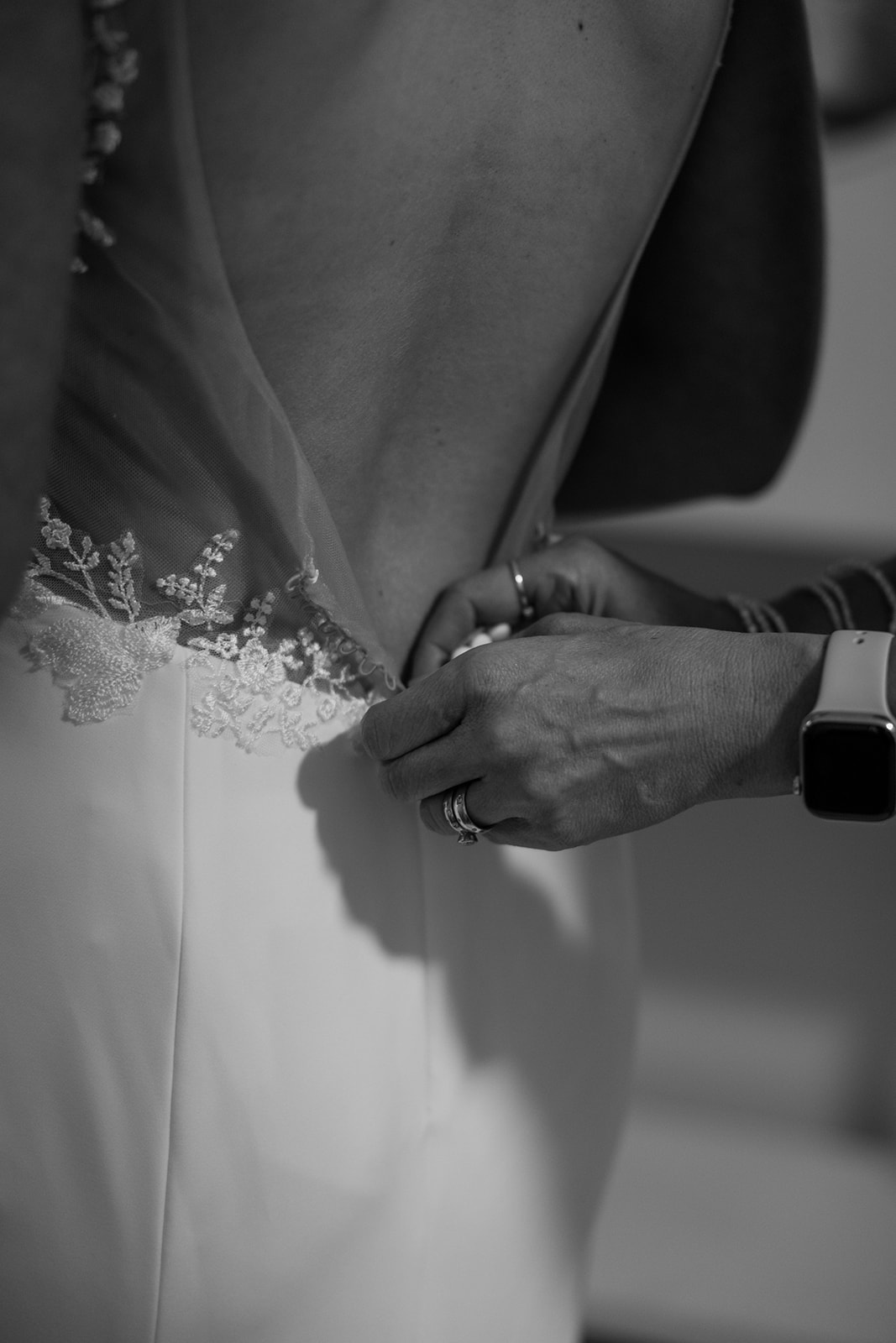 bride gets help zipping her dress