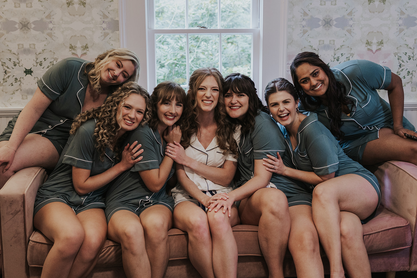 bride poses with her bridesmaids before her stunning wedding ceremony