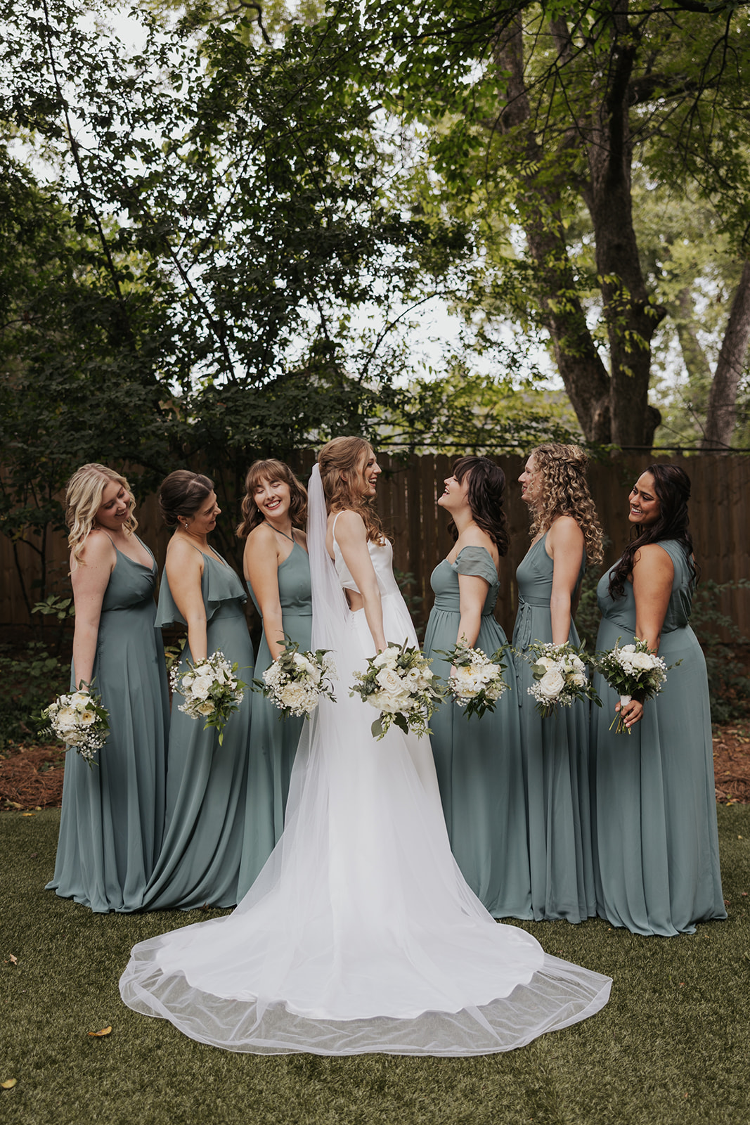 bride poses with her bridesmaids before her stunning wedding day