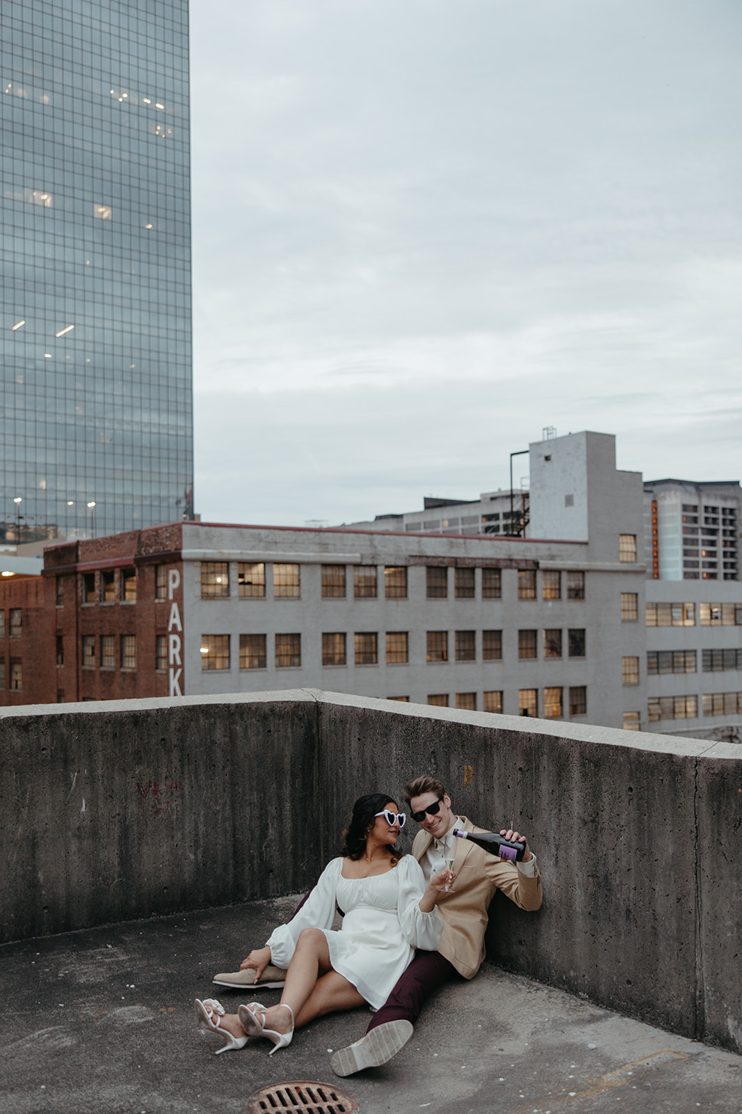 stunning couple pose together on an Atlanta parking garage during their Georgia engagement photoshoot