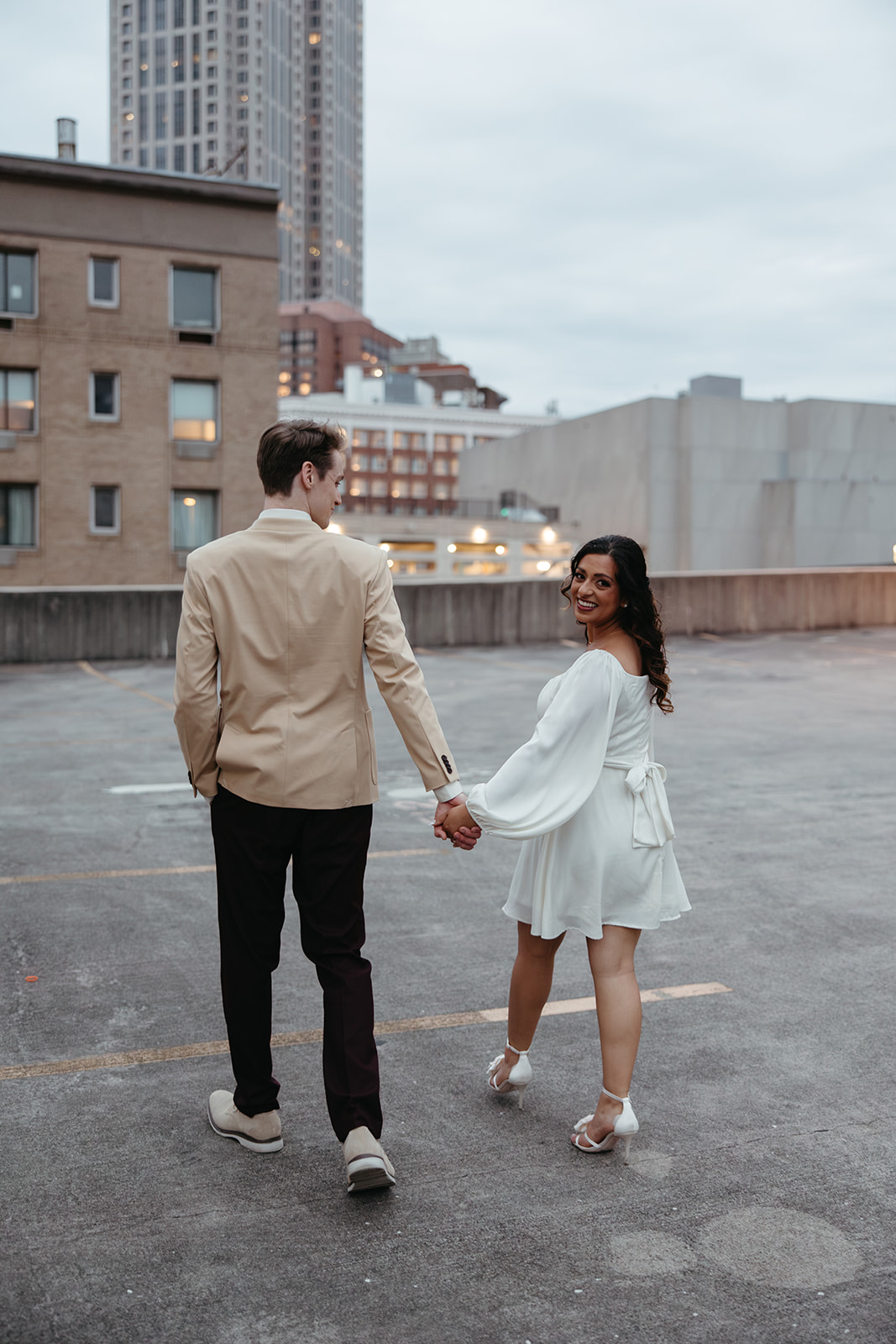 stunning couple pose together on an Atlanta parking garage during their Georgia engagement photoshoot