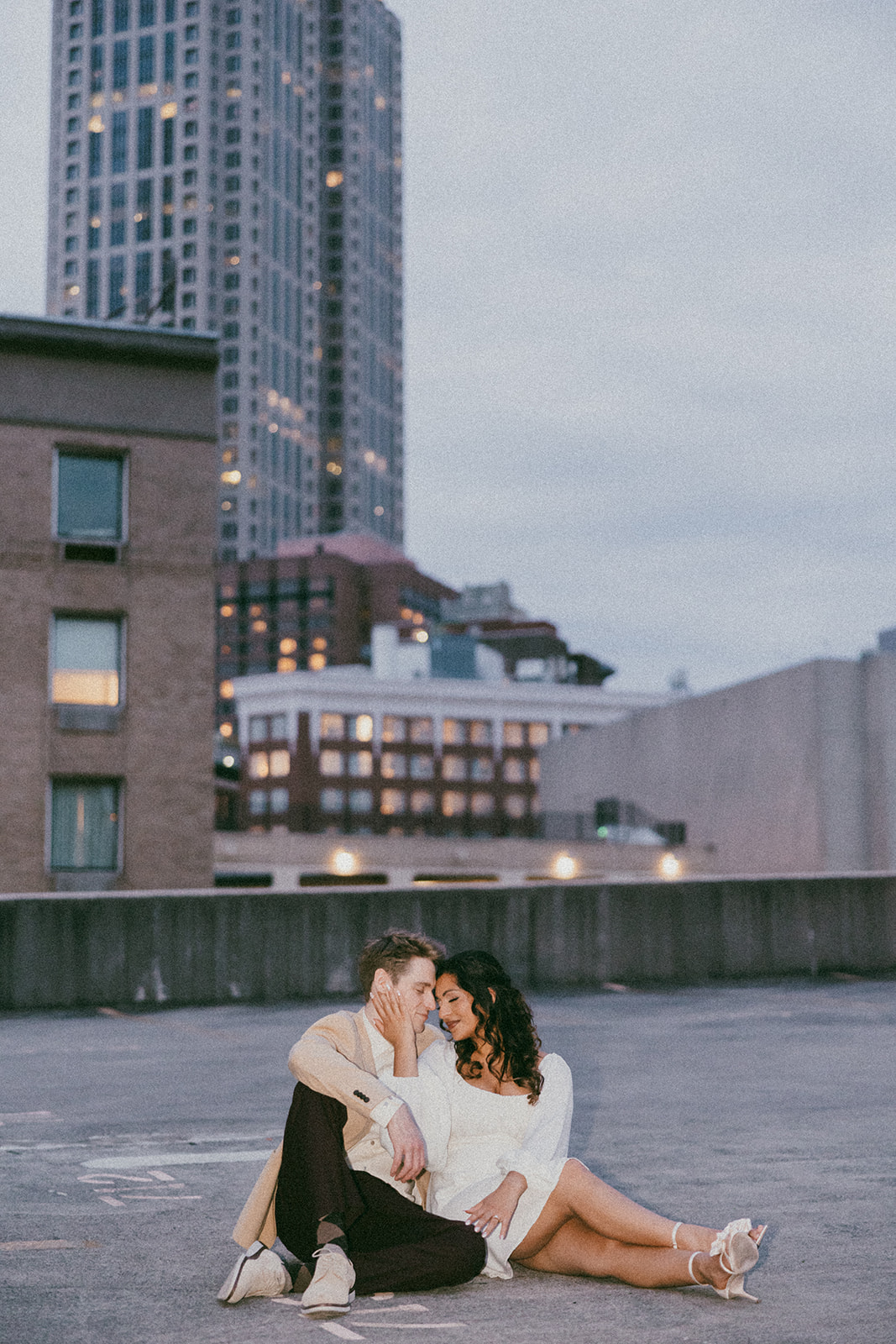 stunning couple pose together on an Atlanta parking garage during their Georgia engagement photoshoot