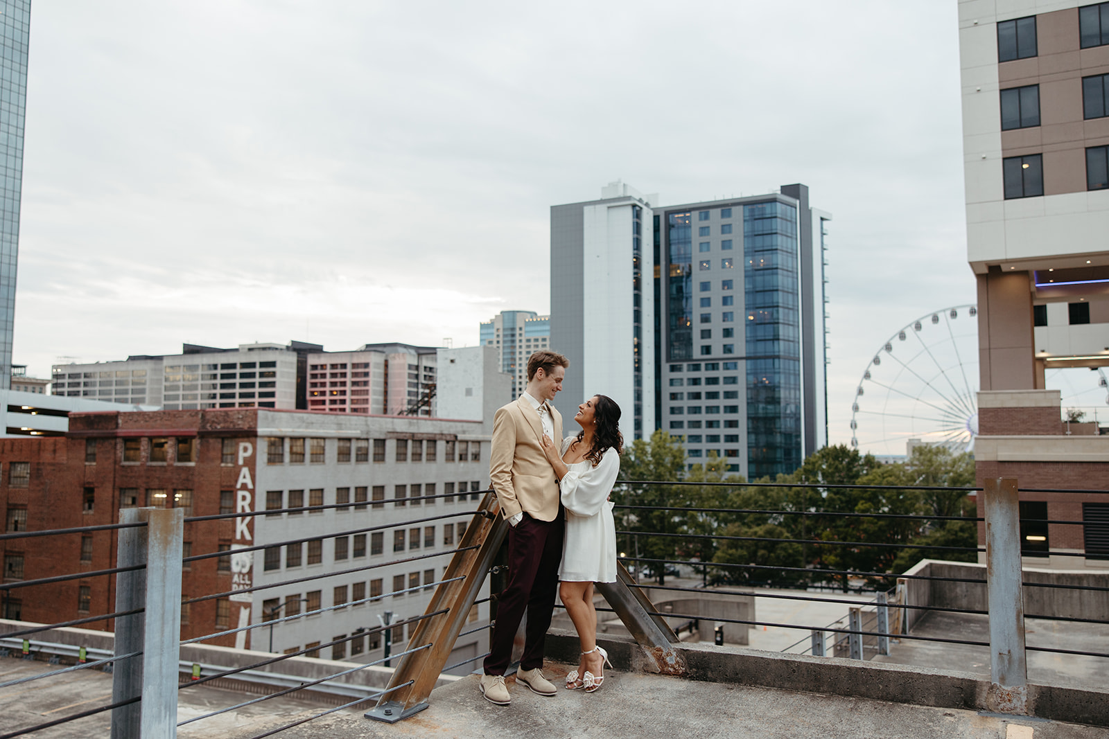 stunning couple pose together on an Atlanta parking garage during their Georgia engagement photoshoot