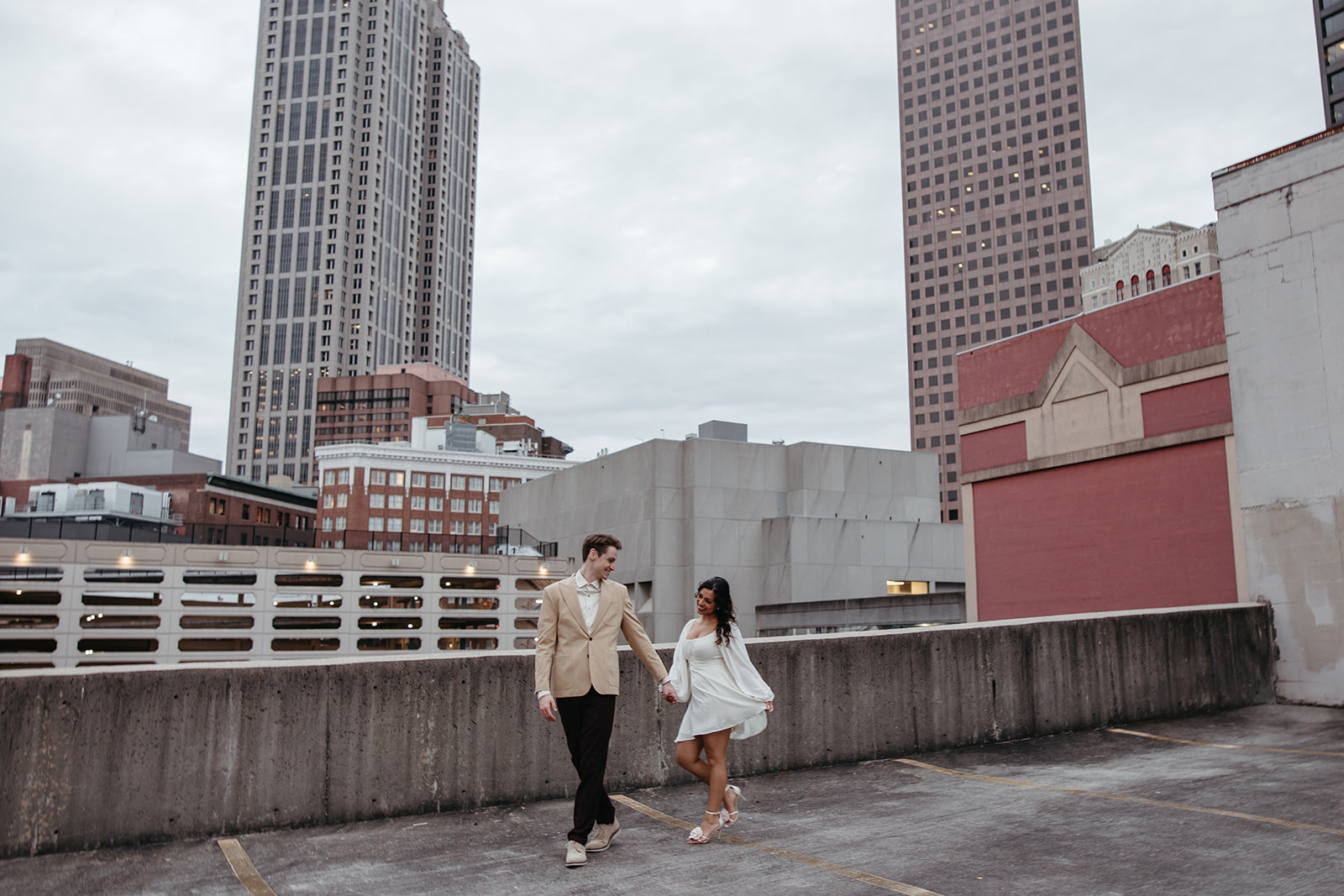 stunning couple pose together on an Atlanta parking garage during their Georgia engagement photoshoot
