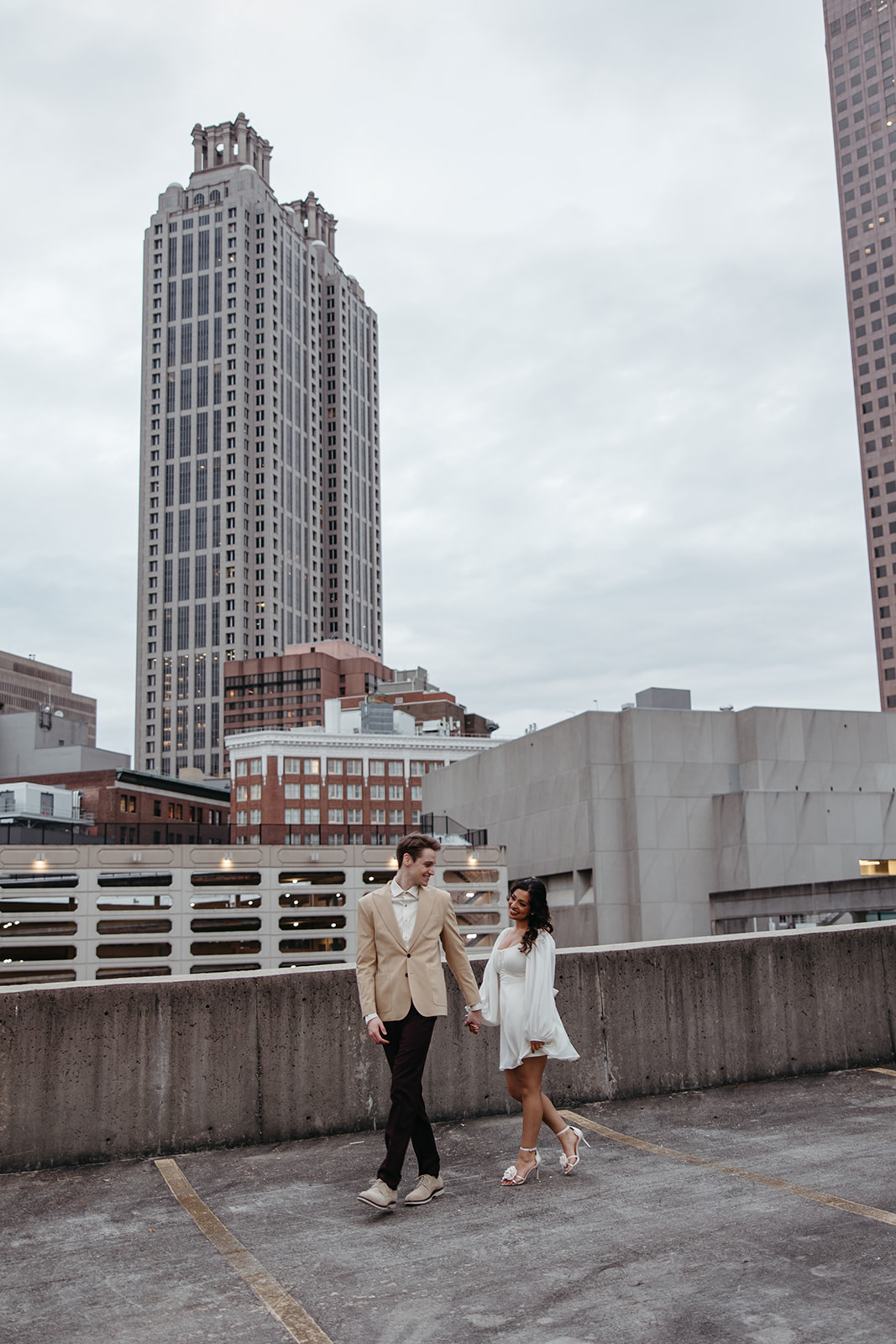 stunning couple pose together on an Atlanta parking garage during their Georgia engagement photoshoot