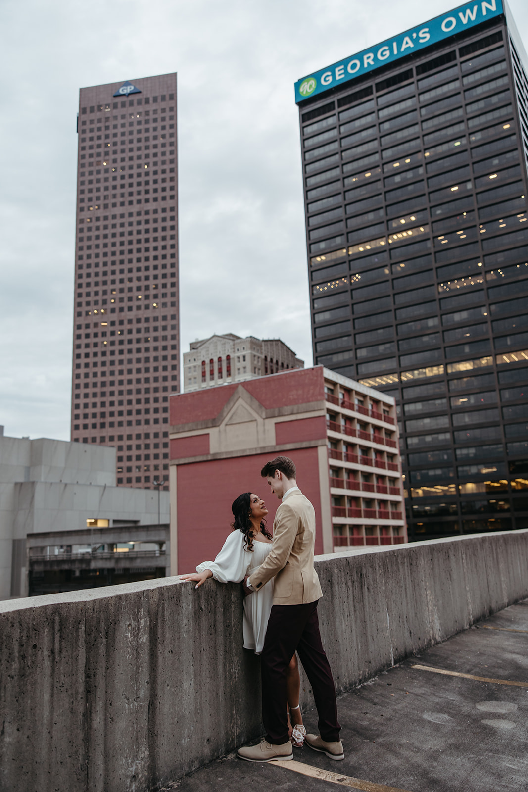 stunning couple pose together on an Atlanta parking garage during their Georgia engagement photoshoot