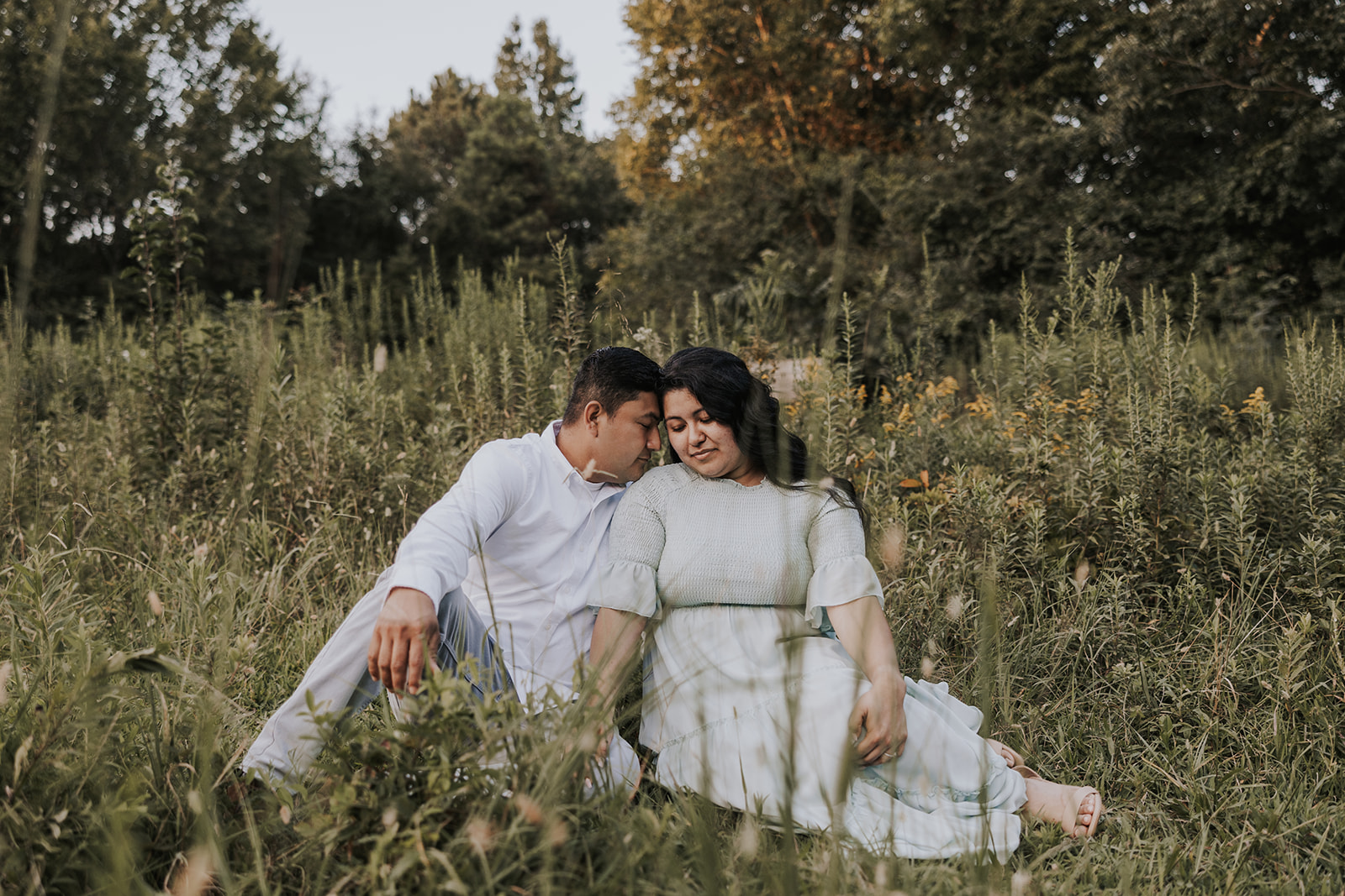 beautiful couple sits in a Georgia field together during their mini session