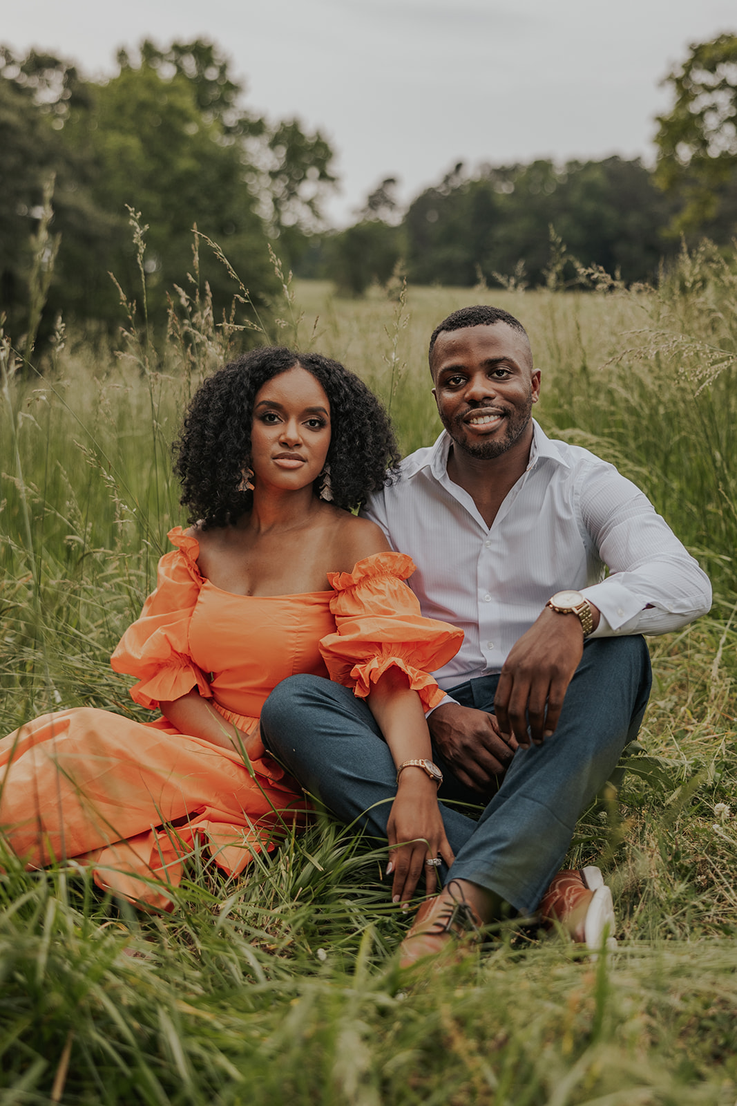 beautiful couple sits in a Georgia field together during their mini session