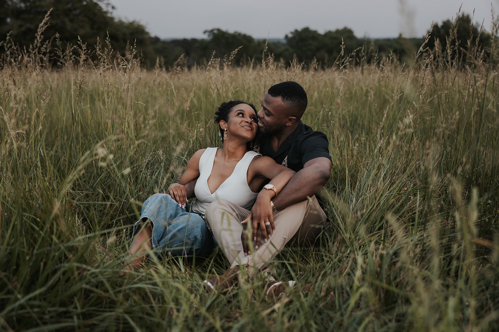 beautiful couple sits in a Georgia field together during their mini session