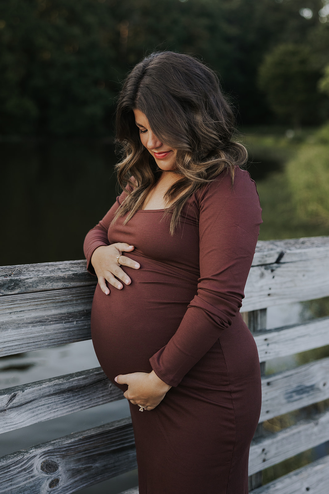 stunning future mom poses for a maternity photo lakeside