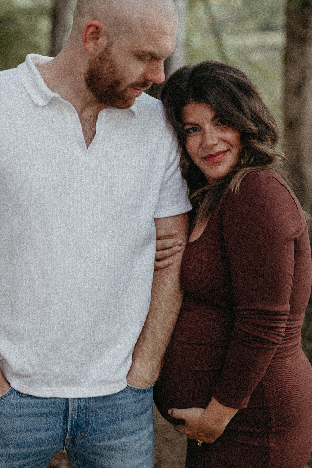 future parents pose together for a photo