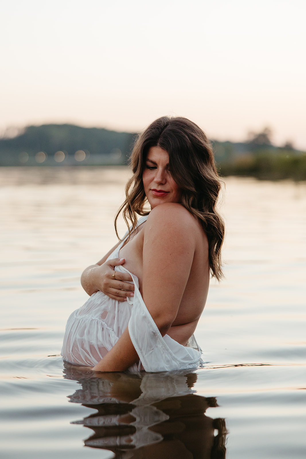 beautiful expecting mother poses for maternity photos in water