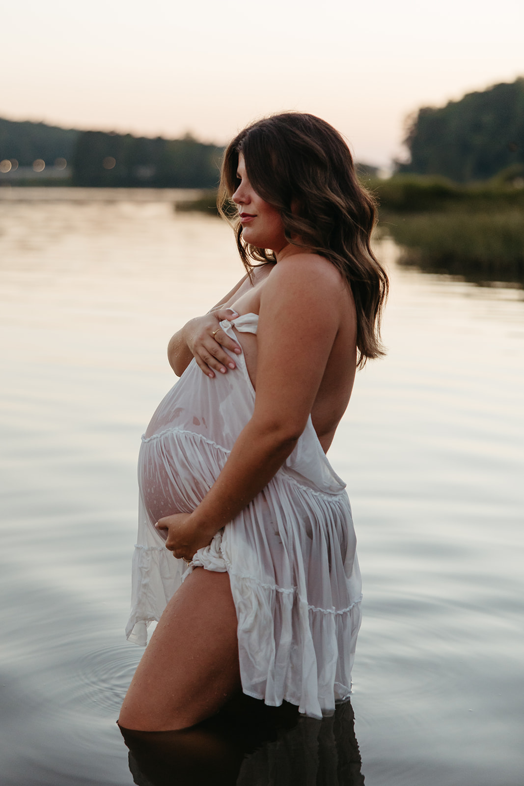 beautiful expecting mother poses for maternity photos in water