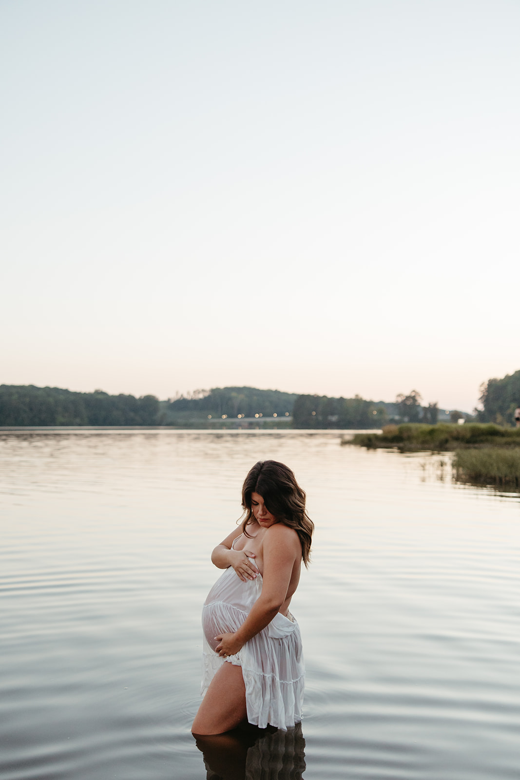 beautiful expecting mother poses for maternity photos in water