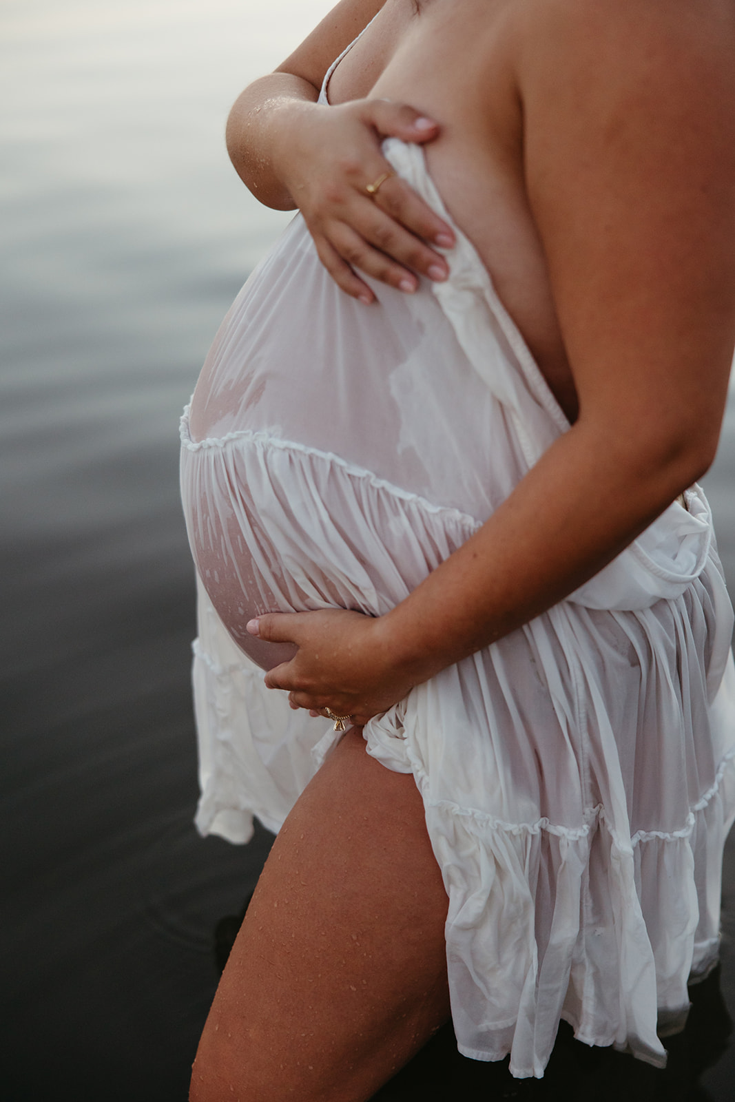 beautiful expecting mother poses for maternity photos in water