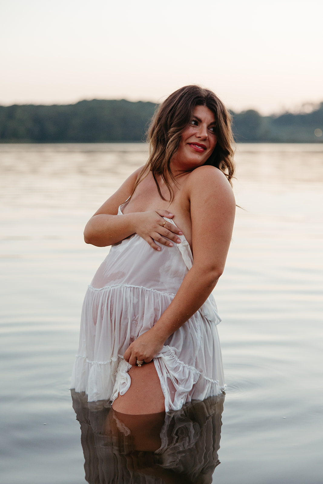 beautiful expecting mother poses for maternity photos in water