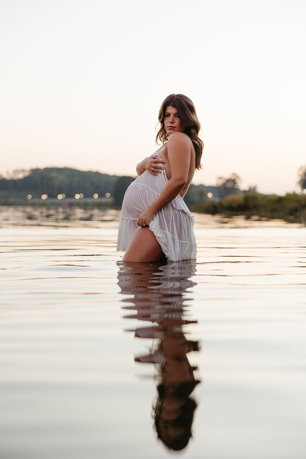 beautiful expecting mother poses for maternity photos in water