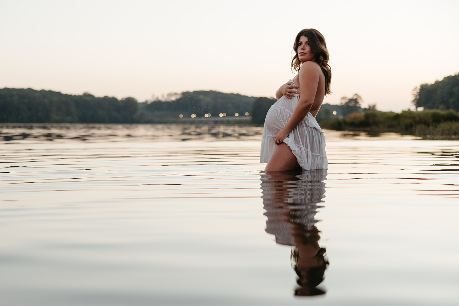 beautiful expecting mother poses for maternity photos in water