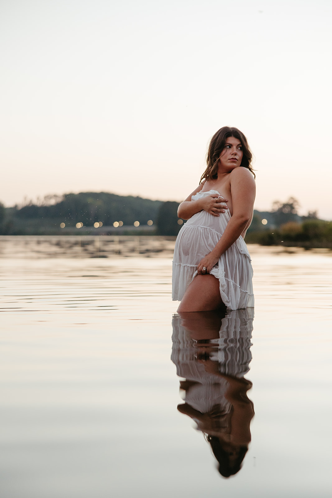 beautiful expecting mother poses for maternity photos in water