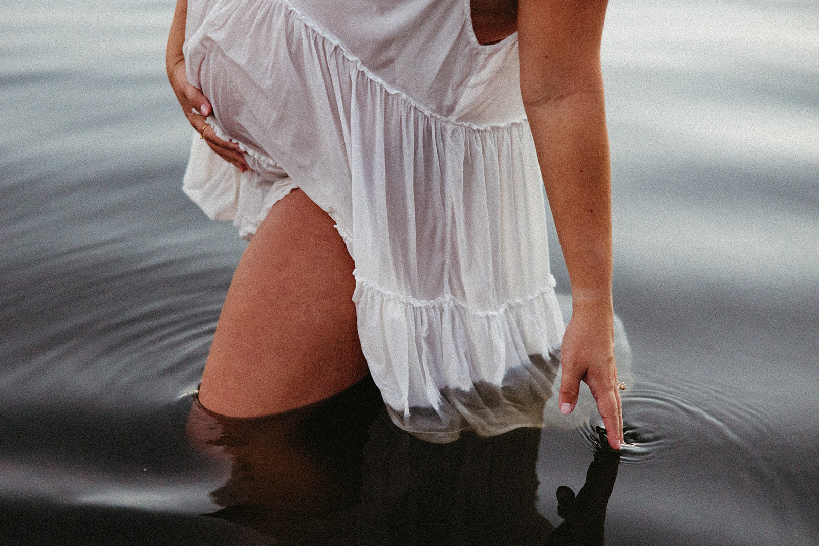 beautiful expecting mother poses for maternity photos in water