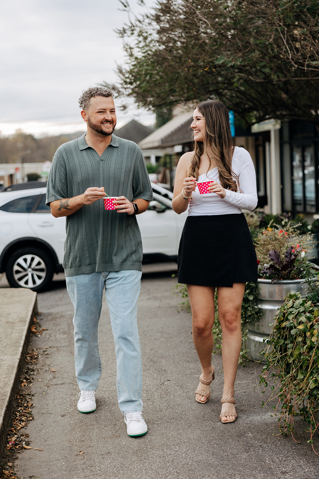 couple walk and talk while they share their frozen yogurt