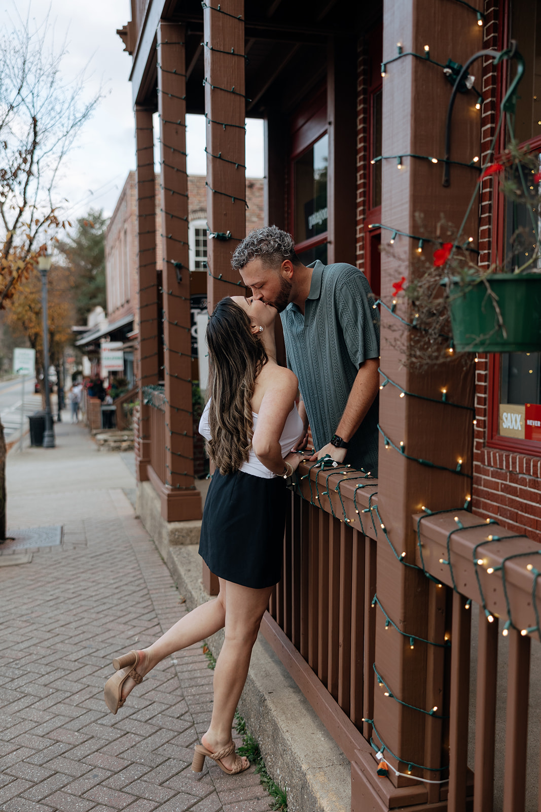 stunning couple pose together romantically downtown of a small Georgia town during their engagement session