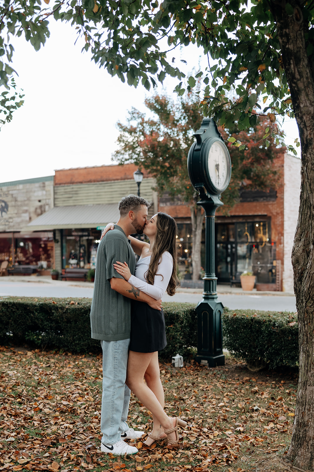 stunning couple pose together romantically downtown of a small Georgia town during their engagement session