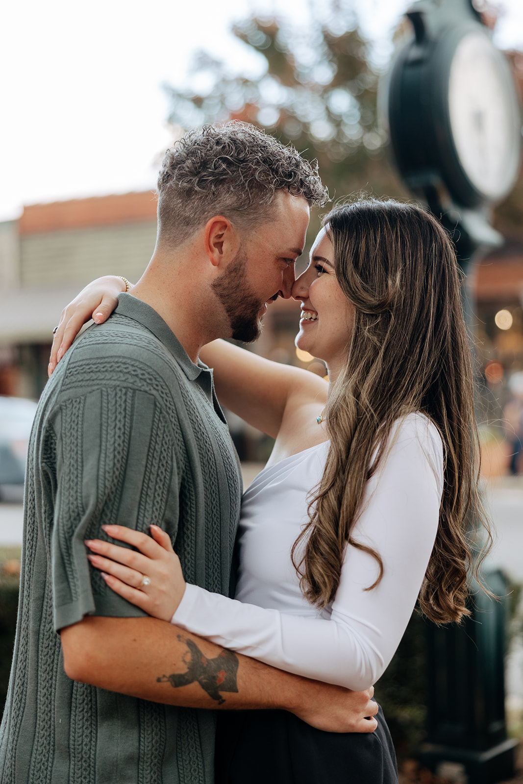 stunning couple pose together romantically downtown of a small Georgia town during their engagement session