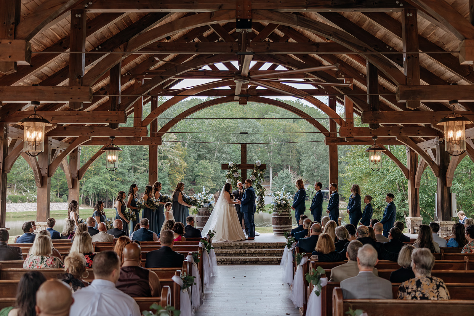 bride and groom stand at the ceremony site at the wedding venue In The Woods 