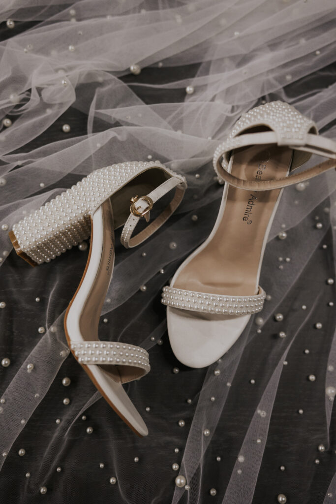 wedding shoes laying on brides veil