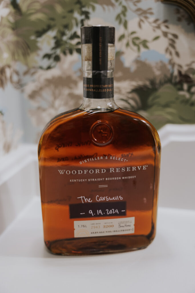 bottle of whiskey with bride and grooms wedding date written on the bottle