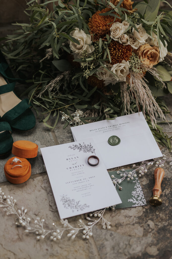 wedding detail photo of bouquet, invitation, and rings