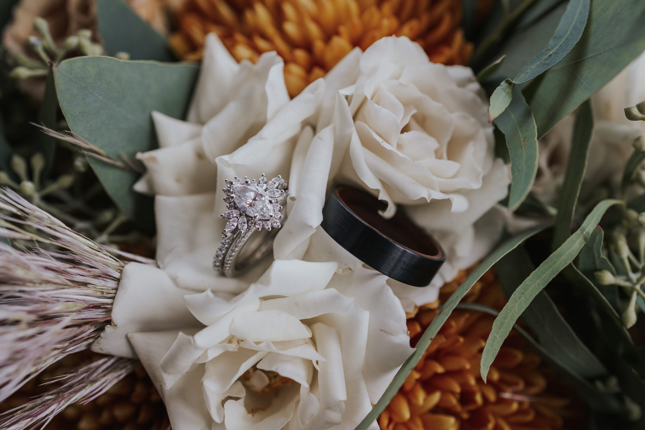 flat lay photo with rings lying on the brides bouquet