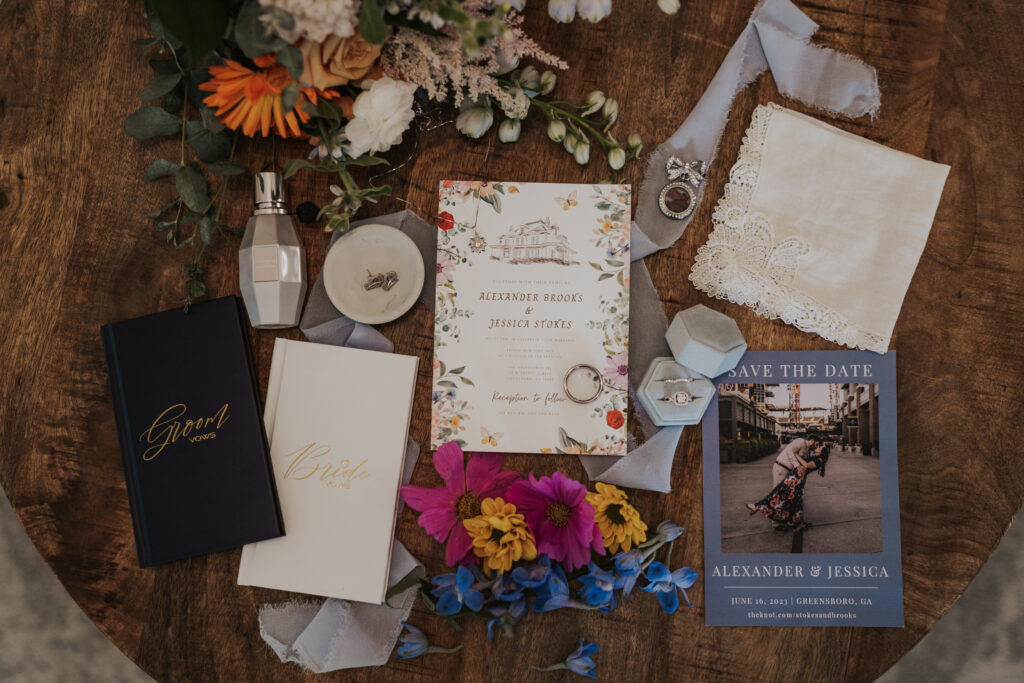 wedding detail flat lay with wedding rings and vow books